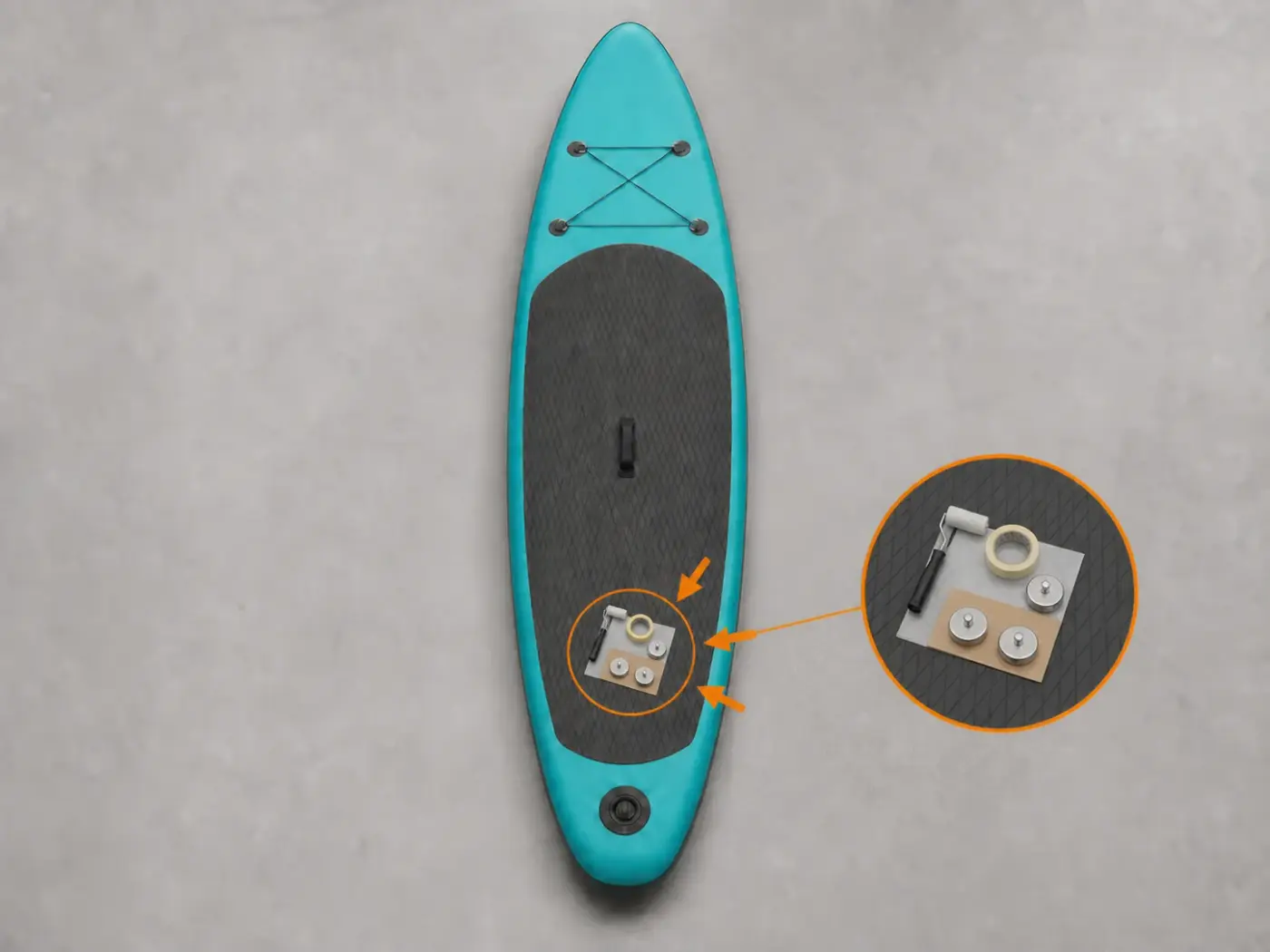 Graues SUP liegt stabil auf einem hellen Arbeitstisch, Deckpad, Roller, Band und flache Platte sind vorbereitet